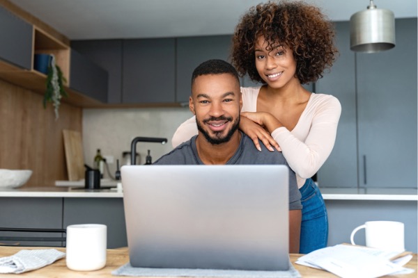 Couple smiling in front of laptop